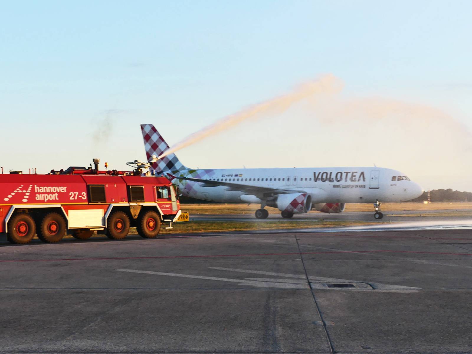 Das Flugzeug Volotea wird von einem Feuerwehrauto mit Wasser abgespritzt